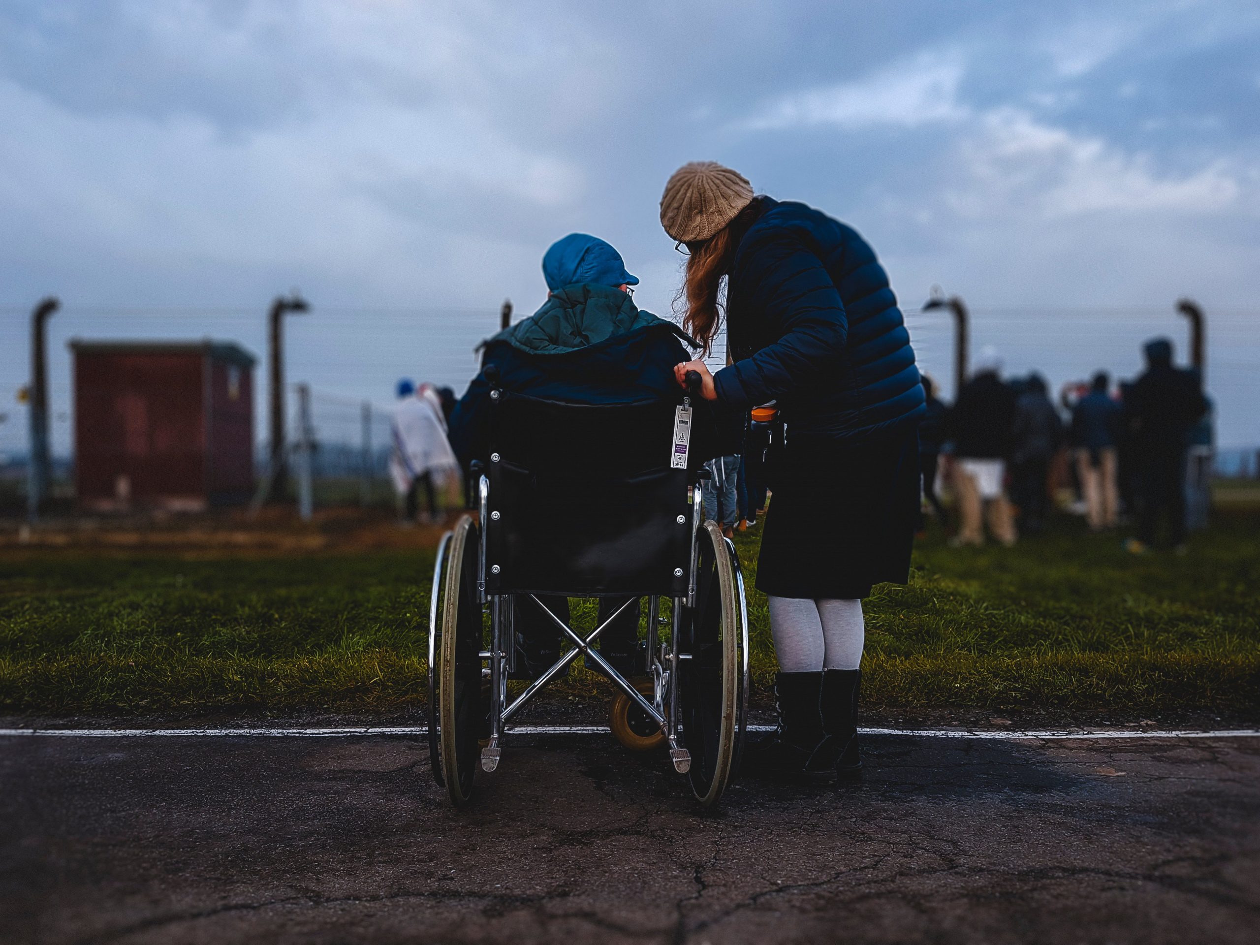 Caregiver and man in wheelchair with blue cap