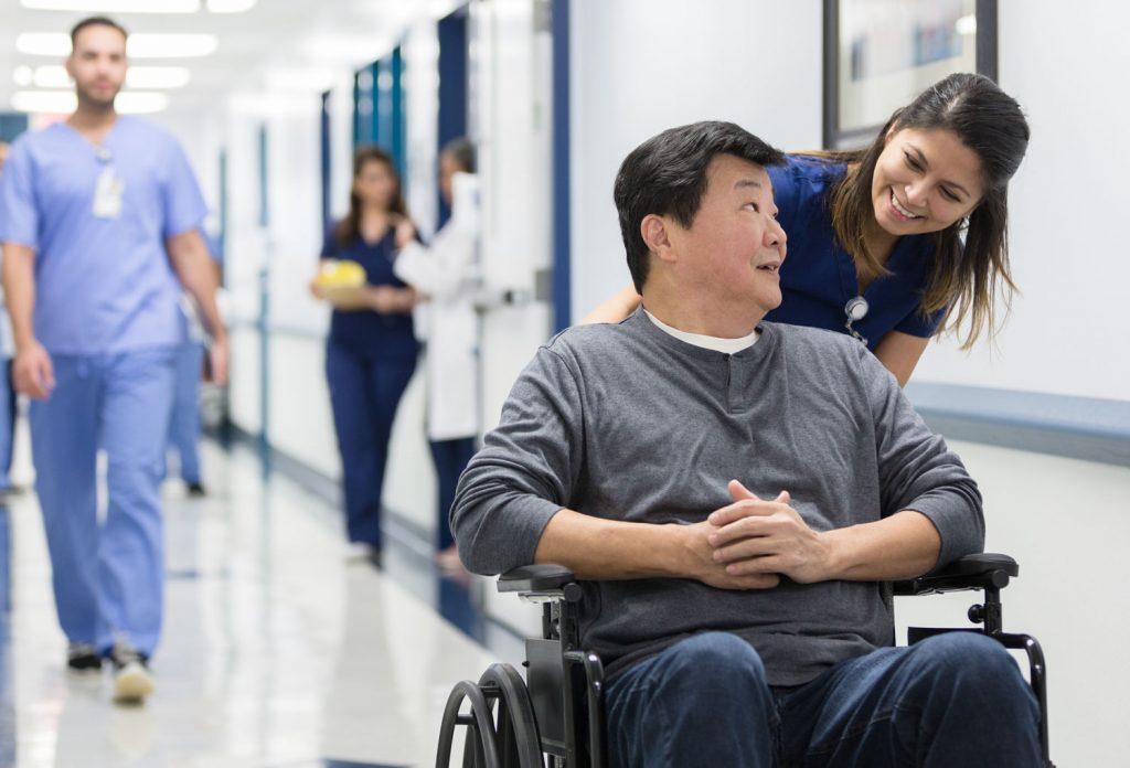 Amramp offers wheelchair ramps and a man is sitting in a wheelchair speaking with a nurse