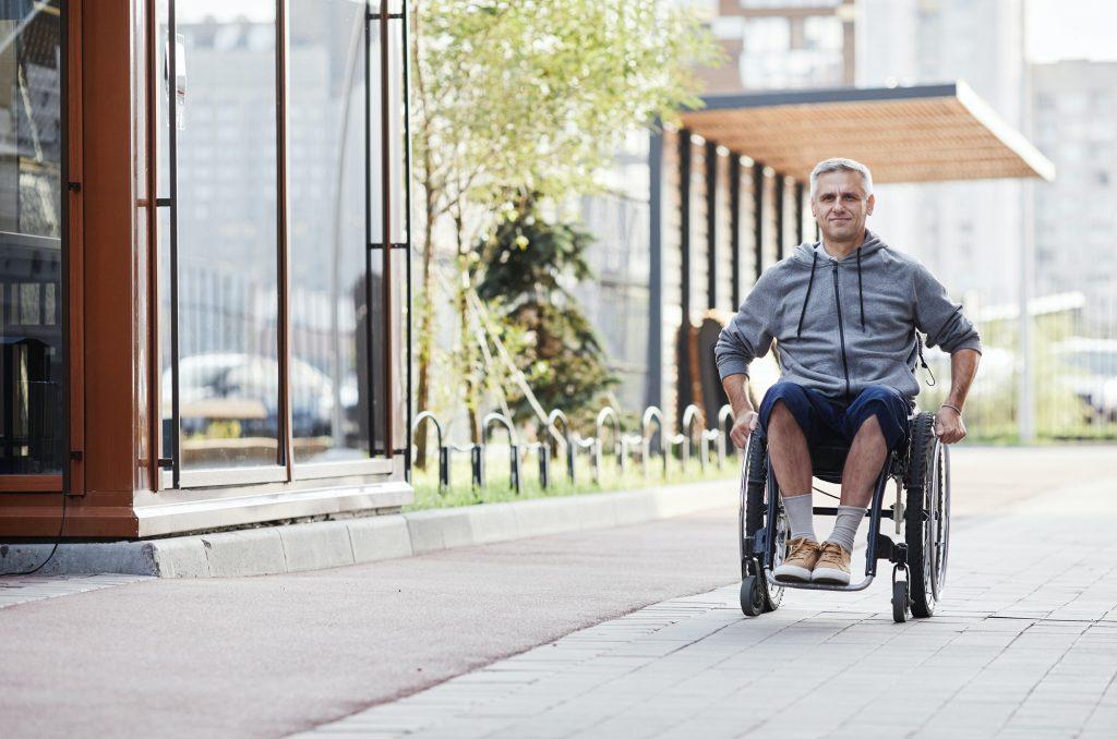 Man in wheelchair walking outdoors