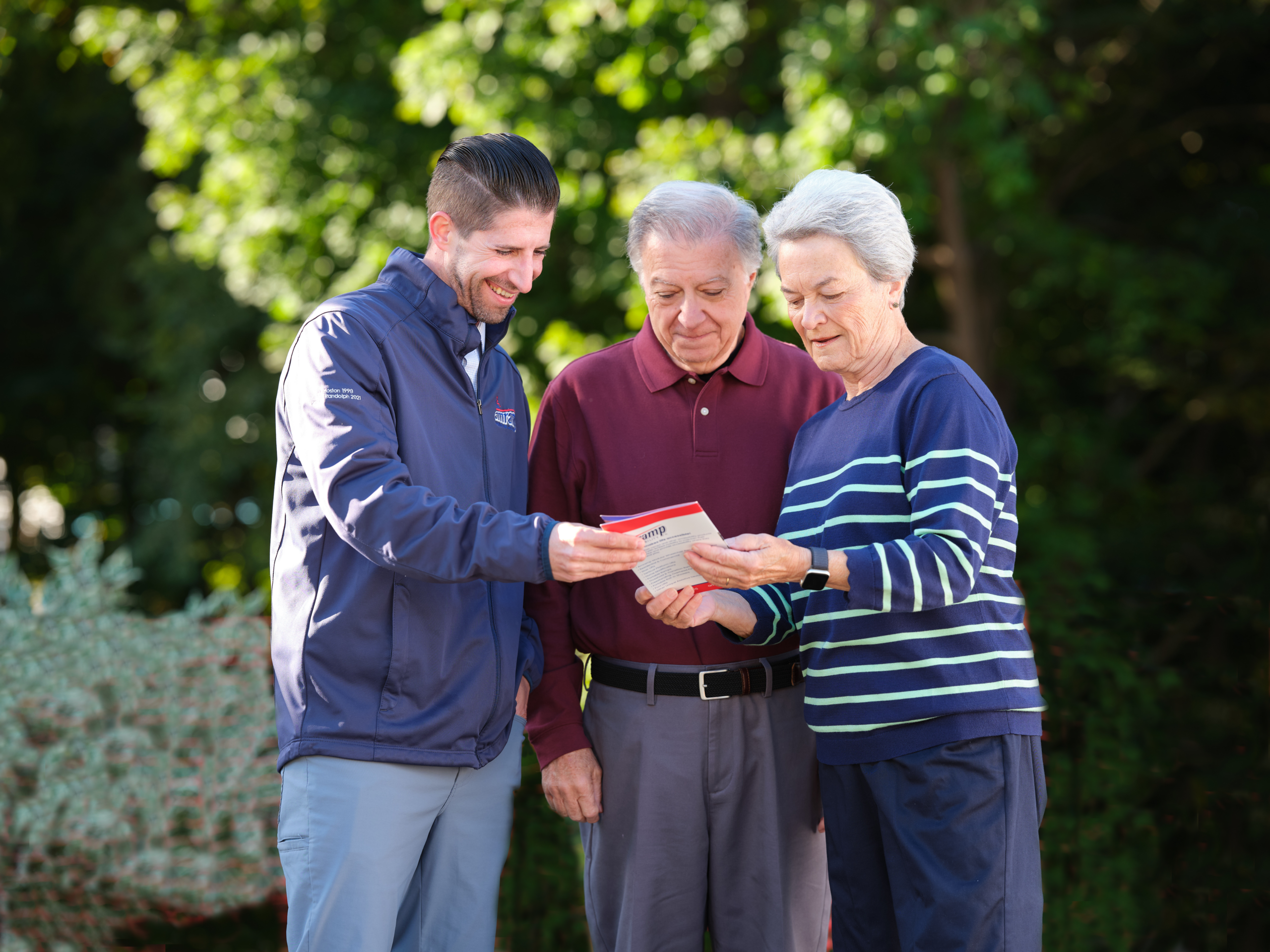A senior couple reviewing a product brochure with an Amramp representative