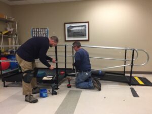 Two Amramp employees install a ramp