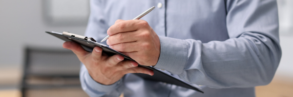 A man with a checklist reviewing the safety and accessibility of a home