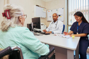 A doctor and a nurse work together with a patient