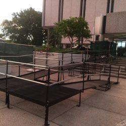Modular steel wheelchair ramp with handrails and turning platforms leading to a City of Fort Lauderdale building entrance.