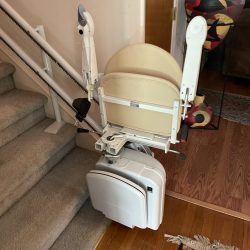 Straight stair lift installed on a carpeted staircase inside a residential home.