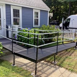 Modular wheelchair ramp providing accessible access to a home's entrance around existing landscaping.