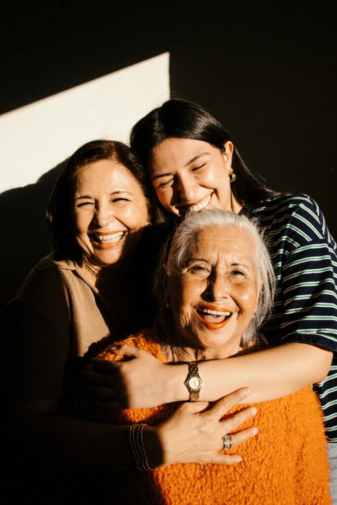 Older woman smiling with family members during a discussion about senior care and support.