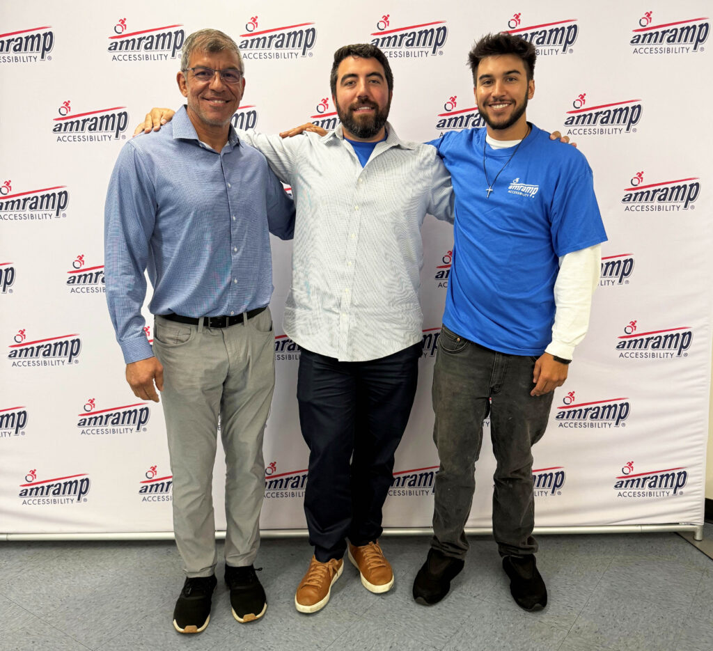 Three Amramp South Florida owners standing together in front of an Amramp Accessibility logo backdrop.