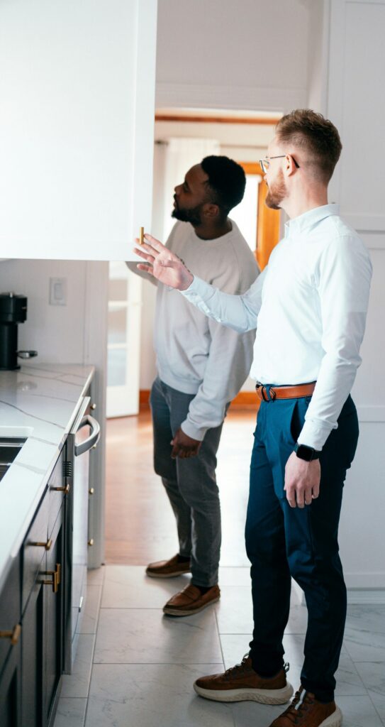 Home accessibility professional reviewing kitchen cabinets with a homeowner during an in-home evaluation.