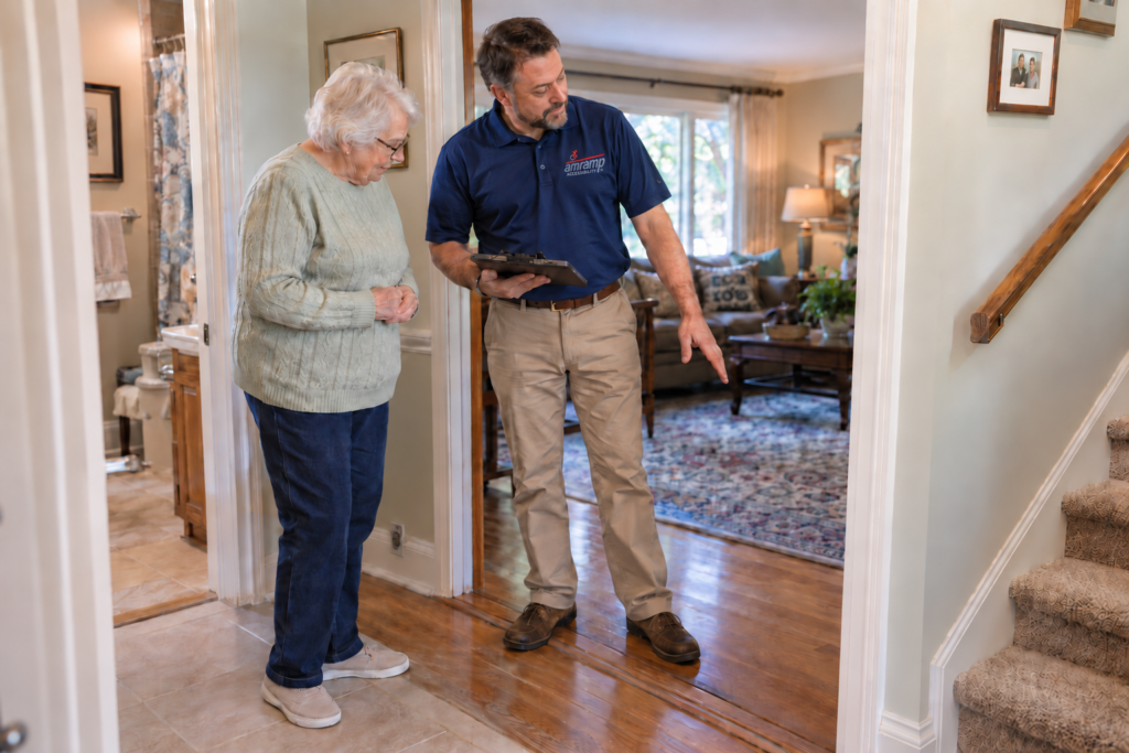 Amramp Accessibility specialist reviewing a home's flooring transition and stairs with an older woman during an in-home accessibility evaluation.