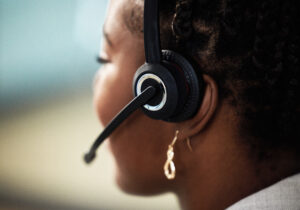 Amramp customer service representative assisting a client over the phone while wearing a headset, providing support and guidance.