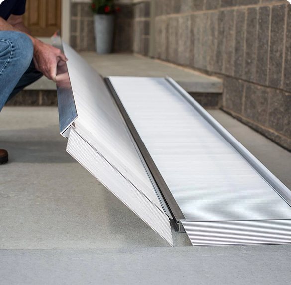 a silver portable ramp being laid down on the ground