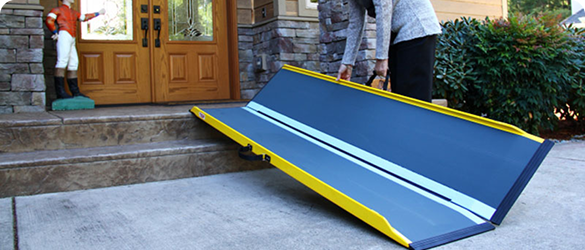 a blue portable ramp being laid out in front of a brown front door