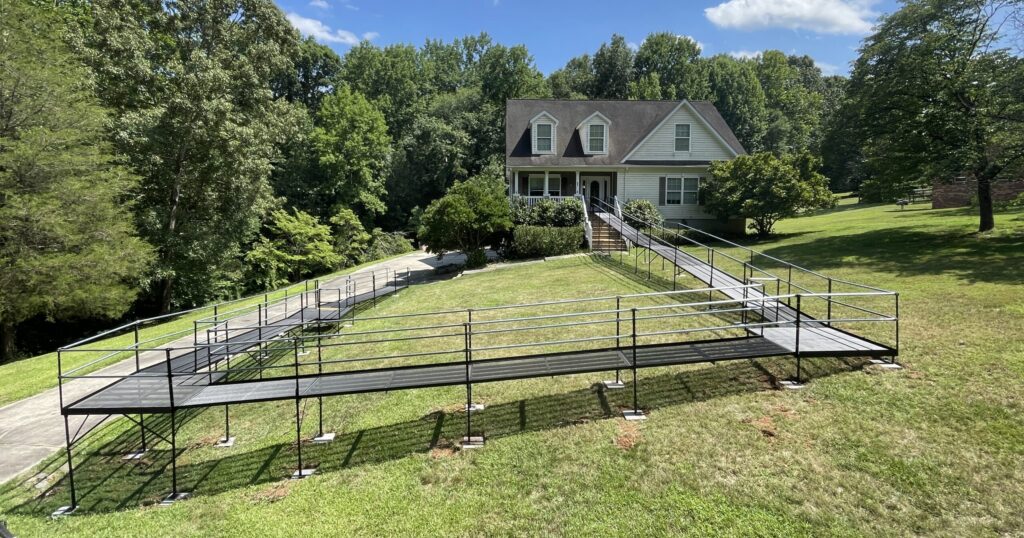 Long modular wheelchair ramp installed on a sloped residential property.