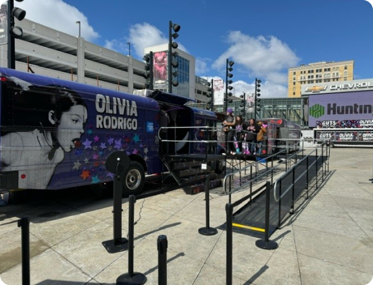 A picture of the Olivia Rodrigo tour bus with a ramp leading from the ground up to the entrance.