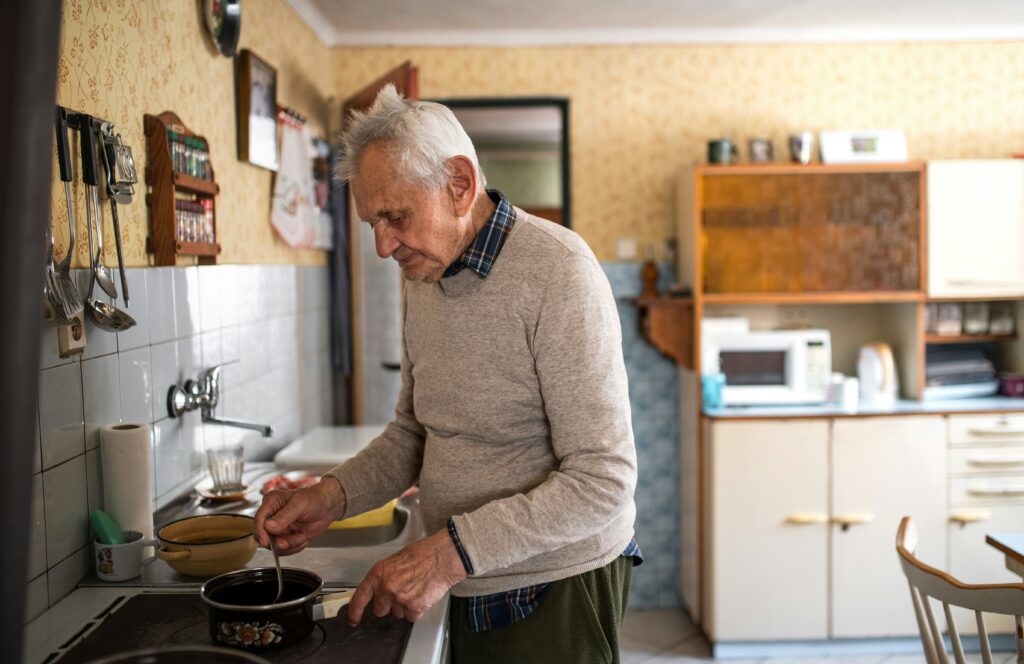Older adult preparing food in their kitchen as part of an independent daily routine.