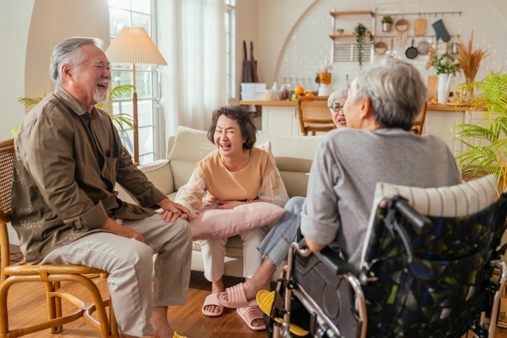Group of older adults enjoying conversation together in a comfortable home setting.