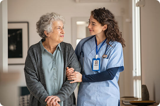 a senior person with a care giver in blue medical scrubs