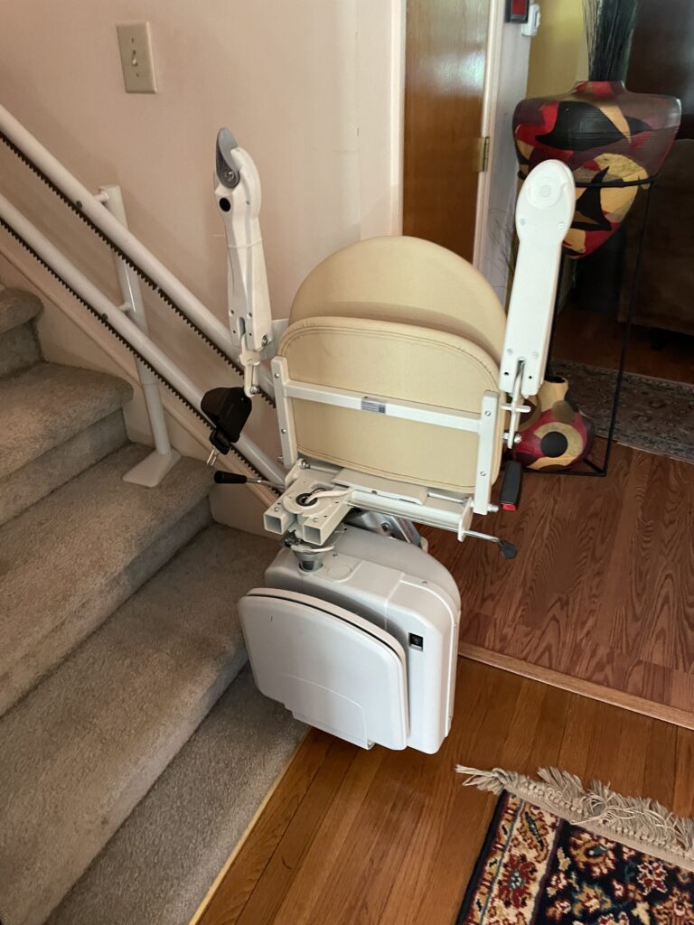 Straight stair lift installed on a carpeted staircase inside a residential home.